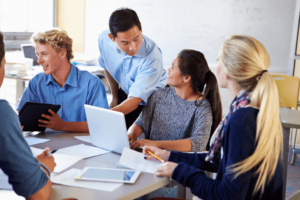 Teacher talking to students on a table