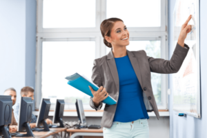 Teacher on the board while students on computer